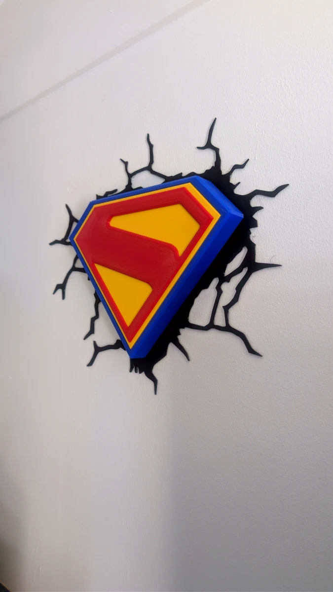Superman shield wall plaque mounted against a white wall, viewed from the front
