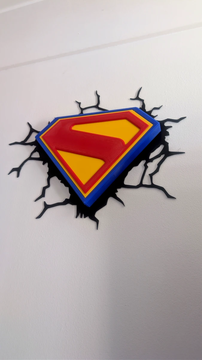 Superman shield wall plaque mounted against a white wall, viewed at an angle